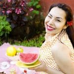 woman holding plate of sliced watermelon