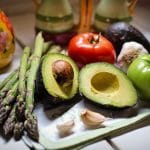 What You Can Eat as a Vegan at a Restaurant That’s Not Salad: asparagus, tomatoes, avocados, and other foods appear on a cutting board