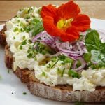 bread with cheese, onions, nasturtium on top