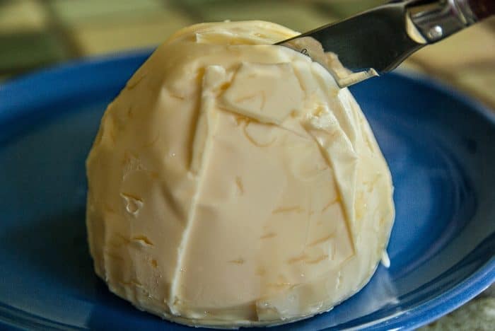 butter in a blue plate and knife